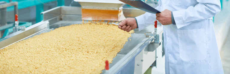 Person in white lab coat inspecting food